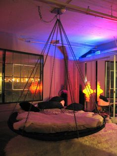 a bedroom with a swing bed in the middle and purple lights on the ceiling above it