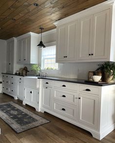 a large kitchen with white cabinets and black counter tops is pictured in this image from the front view