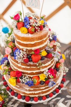 the cake is decorated with flowers and berries