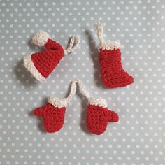 three crocheted red and white christmas ornaments on a polka dot tablecloth,