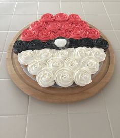 there is a cake with roses on the top and in the shape of a pokeball