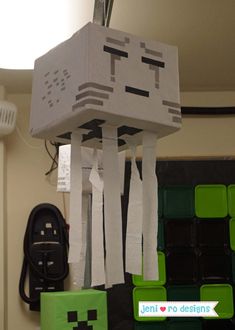 a robot made out of toilet paper hanging from the ceiling