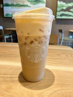 a starbucks drink sitting on top of a wooden table