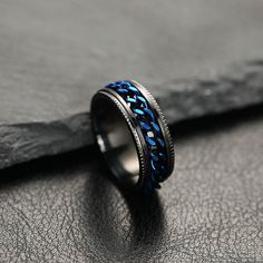 a ring with blue braiding is sitting on top of a piece of black leather