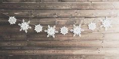 snowflakes are hanging on a wooden wall