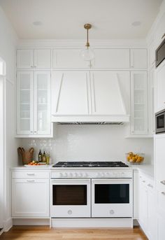 a white kitchen with an oven, stove and microwave in it's center island