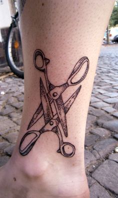 a tattoo on the leg of a person with scissors