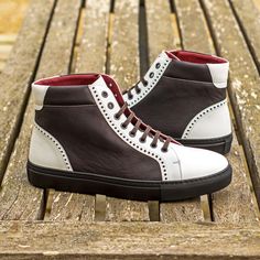 a pair of brown and white shoes sitting on top of a wooden bench next to a park bench