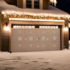 a garage covered in snow and christmas lights