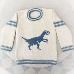 a white sweater with a blue dinosaur on the front, and a circular hole in the back