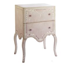 a white chest with two drawers on one side and an ornate design on the other