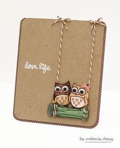 two owls sitting on top of a green piece of paper with the words love life