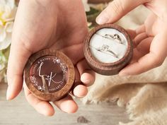 two hands holding an open wooden ring box