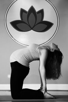 a woman is doing yoga in front of a lotus sign