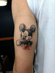 a mickey mouse tattoo on the left arm