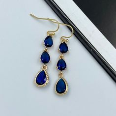 Earrings made of faceted navy blue crystals and gold framed teardrop crystals same color on 14K gold plated French ear hooks. They are perfect for evening and also look great as a statement accessory on a casual outfit! They would make a fabulous gift for Christmas, birthday or Valentines Day! Measurements: The total length from the top of the hook to bottom - 1.85 inches (47 mm) approximately. Teardrop crystals 14 mm x 8 mm Connector crystals: 6 mm x 8 mm The earrings would be a PERFECT GIFT fo Blue Elegant Teardrop Pendant Earrings, Blue Elegant Teardrop Earrings, Elegant Blue Teardrop Earrings, Sapphire Teardrop Crystal Earrings For Party, Blue Drop Crystal Earrings For Party, Sapphire Teardrop Crystal Earrings For Formal Occasions, Sapphire Teardrop Crystal Earrings, Friends Earrings, Drop Earrings Wedding