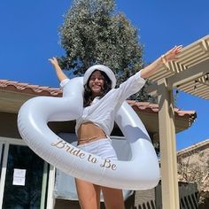 a woman standing on top of an inflatable heart shaped object with her arms outstretched