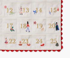 an embroidered table runner with numbers and characters on the front, red trim around the edges