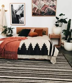 a bed room with a neatly made bed and pictures on the wall