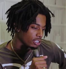 a man with dreadlocks holding a microphone