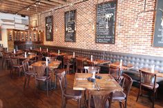 tables and chairs in a restaurant with brick walls