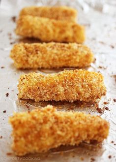 three pieces of breaded food sitting on top of a piece of tin foil covered in seasoning