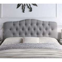 a bed with a gray headboard and white sheets