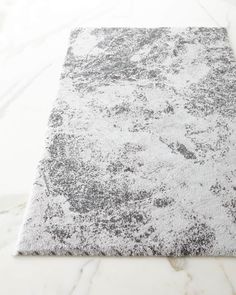 a white and gray rug on a marble floor