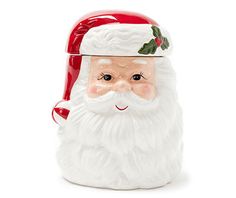 a santa claus cookie jar with holly berries on it's head and eyes, sitting in front of a white background