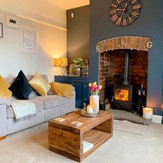 a living room filled with furniture and a fire place in front of a clock on the wall