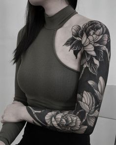 a woman with a flower tattoo on her arm and shoulder is posing for the camera