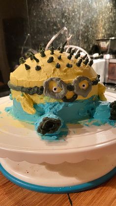 a cake with yellow frosting and blue icing on top of a wooden table