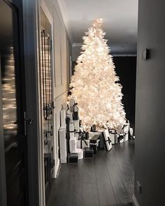 a white christmas tree with presents under it