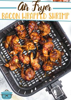 an air fryer with bacon wrapped shrimp on it and text overlay that reads, air fryer bacon wrapped shrimp