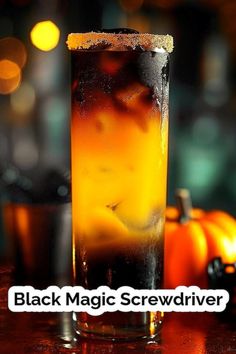 a tall glass filled with liquid sitting on top of a table next to an orange pumpkin