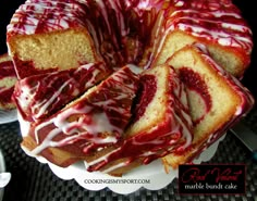 a bundt cake with red and white icing on it sitting on a plate