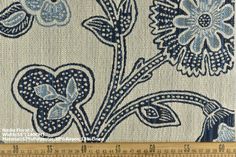 a blue and white floral design on fabric with a ruler in front of the image