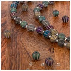 a wooden table topped with lots of glass beads