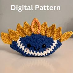 a crocheted blue and white stuffed animal with leaves on it's head