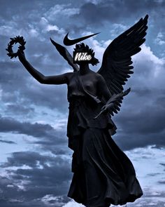 an angel statue with a nike sign on it's head and wings in front of a cloudy sky