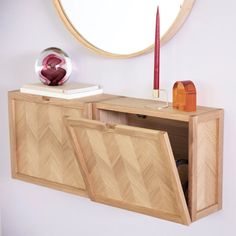 a wooden cabinet with two doors open in front of a round mirror on the wall