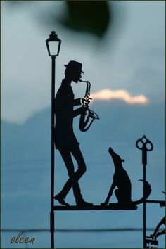 the silhouette of a man and his dog on top of a flag pole with words written in spanish