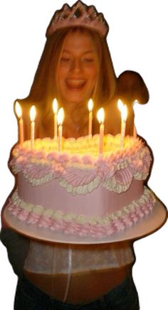 a woman holding a birthday cake with lit candles