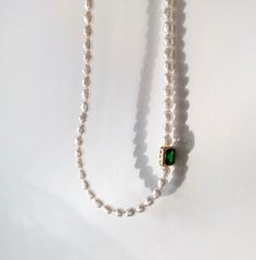 Handcrafted with care, this necklace features lustrous baroque pearls and vibrant emerald green gemstone, elegantly arranged to create a stunning contrast. The rich green hues of the emeralds complement the shimmering pearls, making this necklace a timeless and versatile accessory. Features: Handcrafted Elegant and versatile design Perfect for both casual and formal occasions Makes a thoughtful gift for someone special Specifications: Material: Emerald green zircon, cultured baroque pearls Lengt Green Beaded Necklace With Pearl Drop For Gift, Elegant Green Pearl Drop Necklaces, Green Baroque Pearl Jewelry For Gift, Elegant Green Necklaces With Pearl Drop, Elegant Green Pearl Necklace With Pendant, Elegant Green Single Strand Pearl Necklace, Green Pearl Drop Beaded Necklaces, Green Pearl Necklace With Pearl Charm, Green Pearl Necklace With Round Beads And Pearl Drop