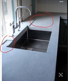 two red circles are shown in the middle of a kitchen sink with no faucet