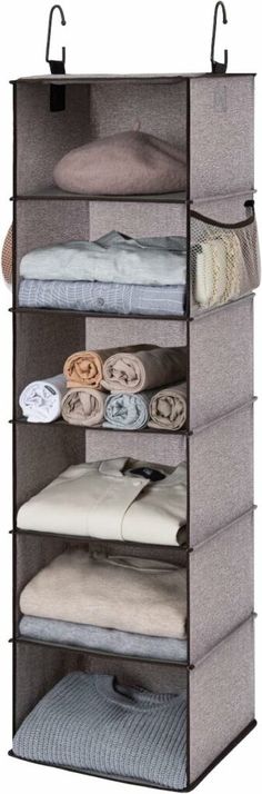 an over the door hanging closet organizer with four shelves and six folded clothes on it