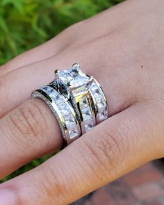 a woman's hand with two rings on top of her finger and the ring is made out of gold and white diamonds