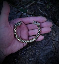 This is one special piece of metal, a Norse viking arm ring with wolf heads, a perfect present for any modern pagan warrior. Purchase it to surprise your man for the holidays, or get one of these for yourself, you know you deserve it. The bracelet is made out of bronze, hence the golden color. It is cast as a single piece of metal, so it is very sturdy and durable, created out of a special alloy that is resistant to any corrosion and color change. The size can be slightly corrected to better acc Viking Style Handmade Gold Jewelry, Handmade Viking Gold Jewelry, Handmade Viking Style Gold Jewelry, Bronze Viking Jewelry For Ceremonial Occasions, Bronze Viking Jewelry Collectible, Viking Style Bronze Jewelry Gift, Viking Style Handmade Bracelets As Gift, Handmade Viking Style Bracelets For Gifts, Viking Style Metal Bracelet For Gift