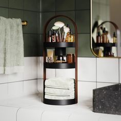 there is a shelf in the bathroom with towels and other items on it next to a mirror