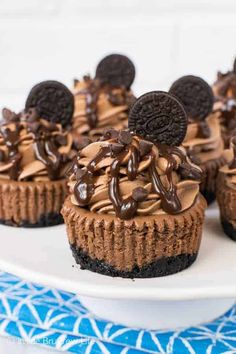 chocolate oreo cookie cupcakes on a white plate with blue and white napkin